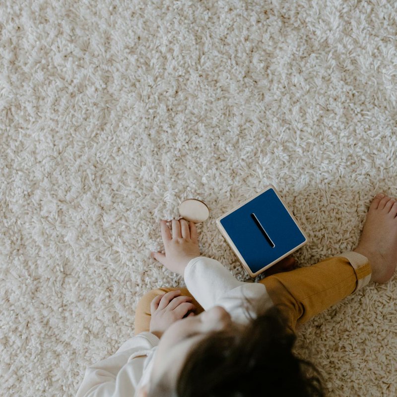Toddler sitting on a soft carpet floor