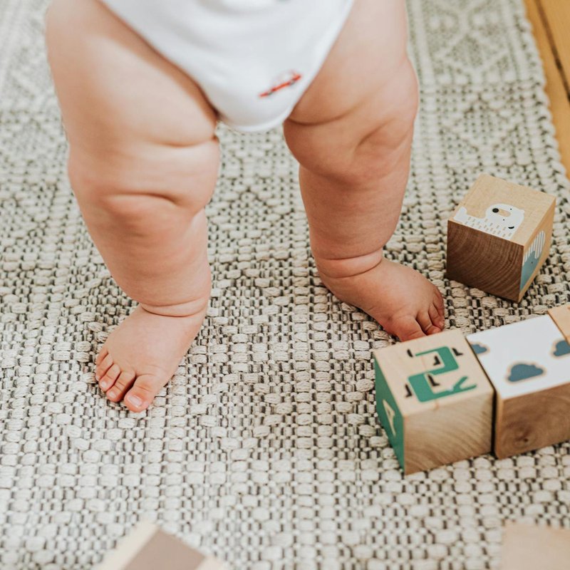 Baby walking on a patterned area rug